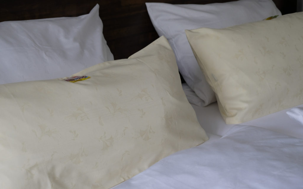 image représentant quatres oreillers posés sur un lit double